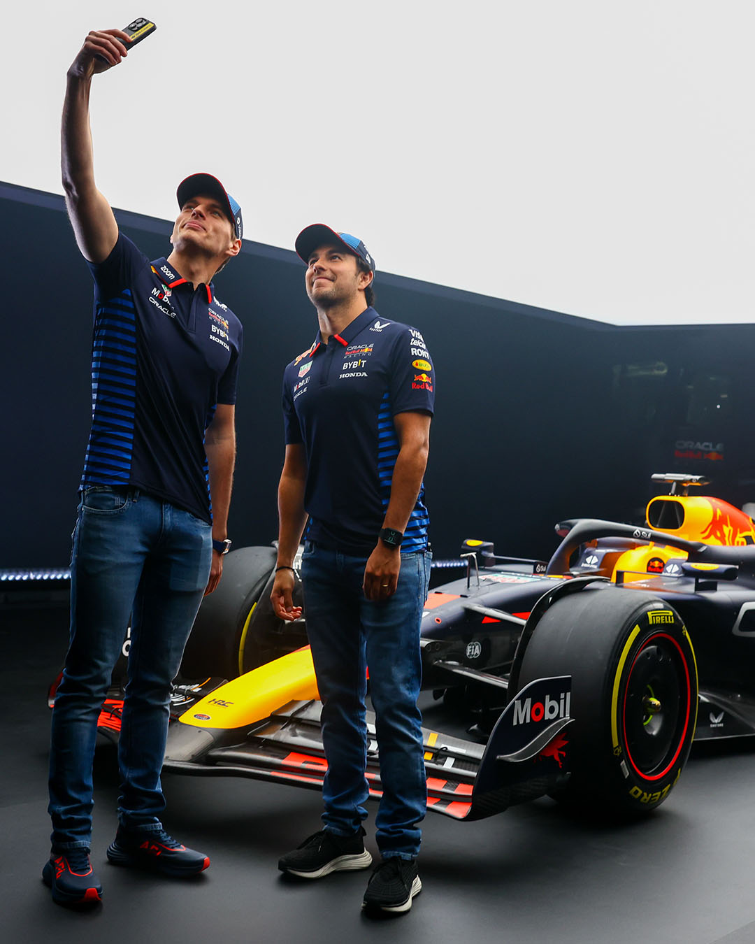 Max Verstappen and Checo Perez take a selfie with the RB20 behind them. 2024 Season
