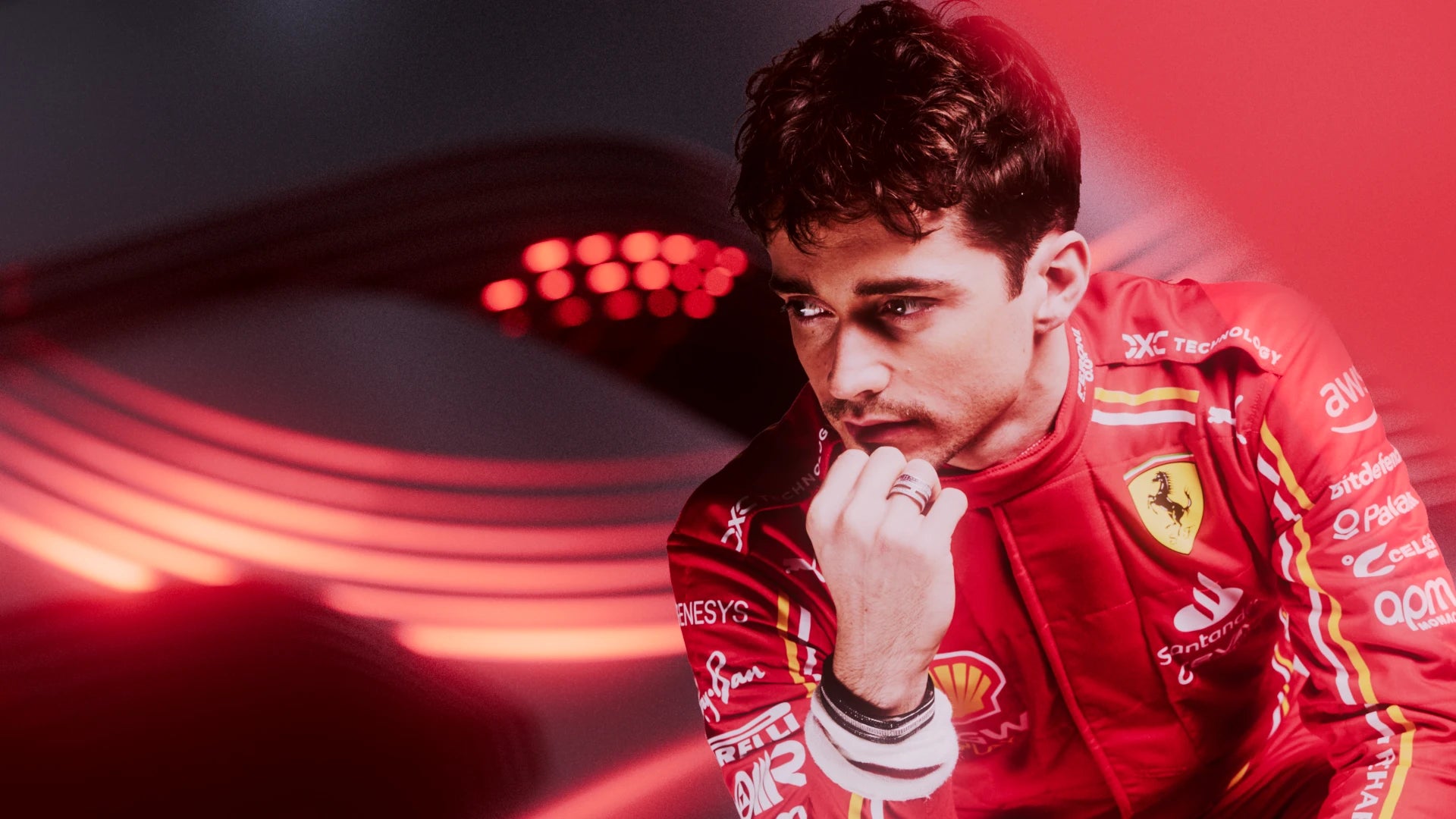Person wearing a red racing suit with visible branding against a blurred background