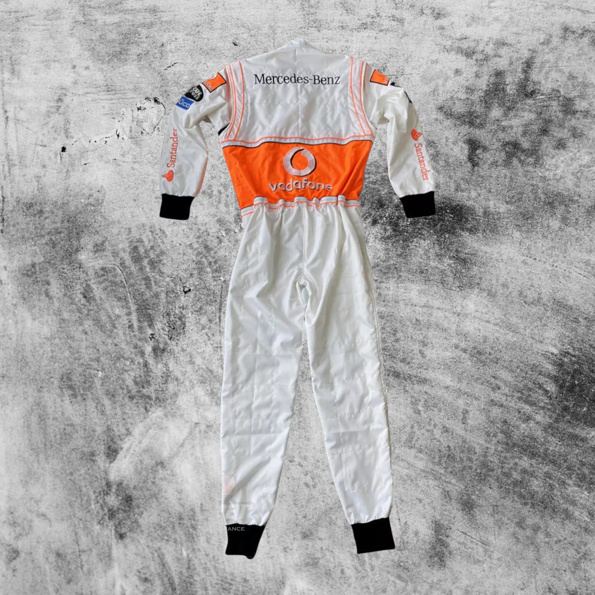 White racing suit with orange accents and Mercedes-Benz branding on a textured gray background